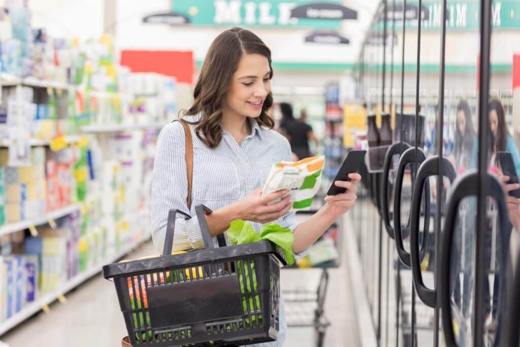 Young woman reads label on frozen food product - SDI Productions - Getty Images Signature